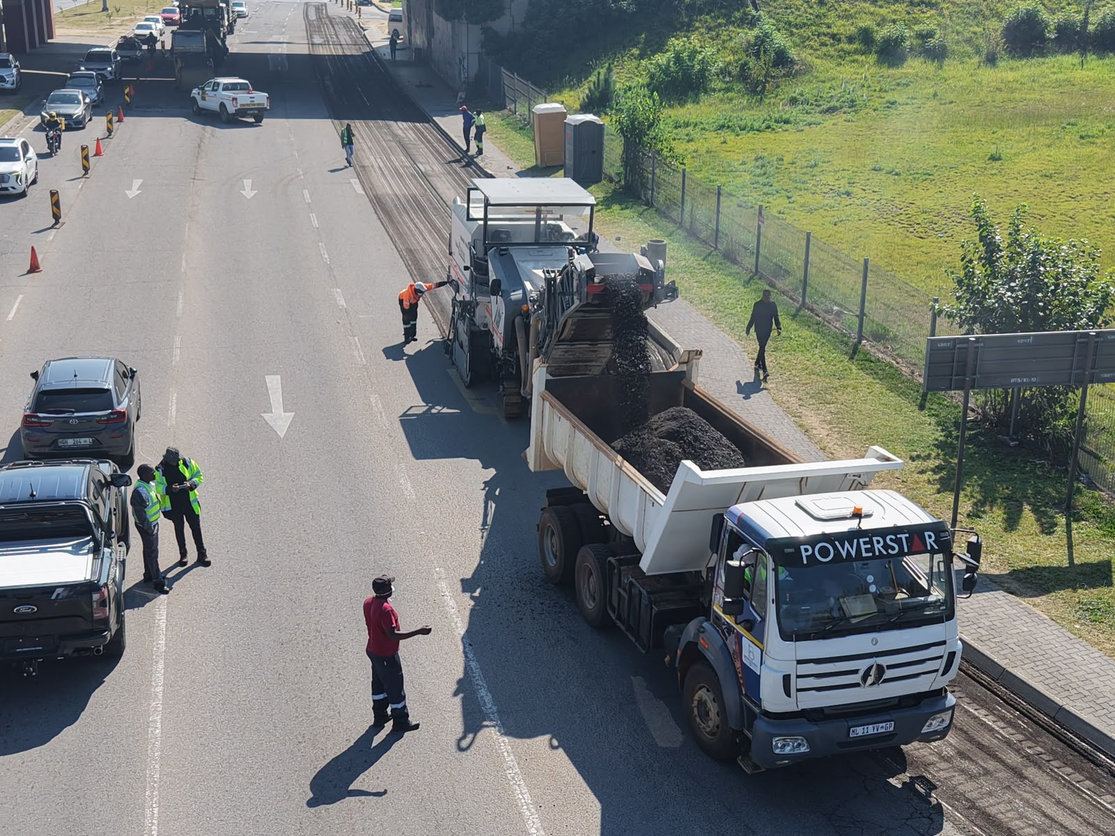 Road construction site with heavy machinery laying asphalt